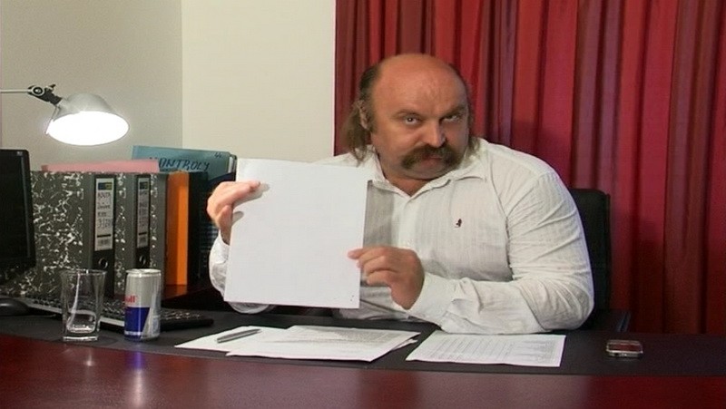 Mikuláš Vareha ukazuje dokumenty za pracovným stolom